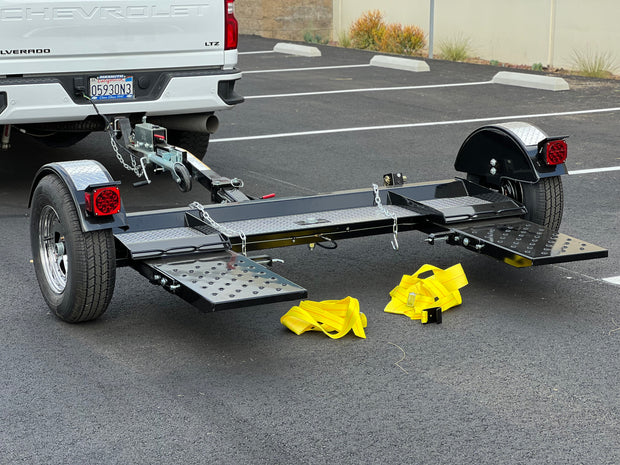 "Side profile of car tow dolly with secure straps and Demco brakes"